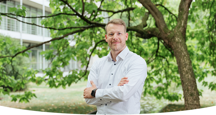 Mann mit gekreuzten Armen im Park